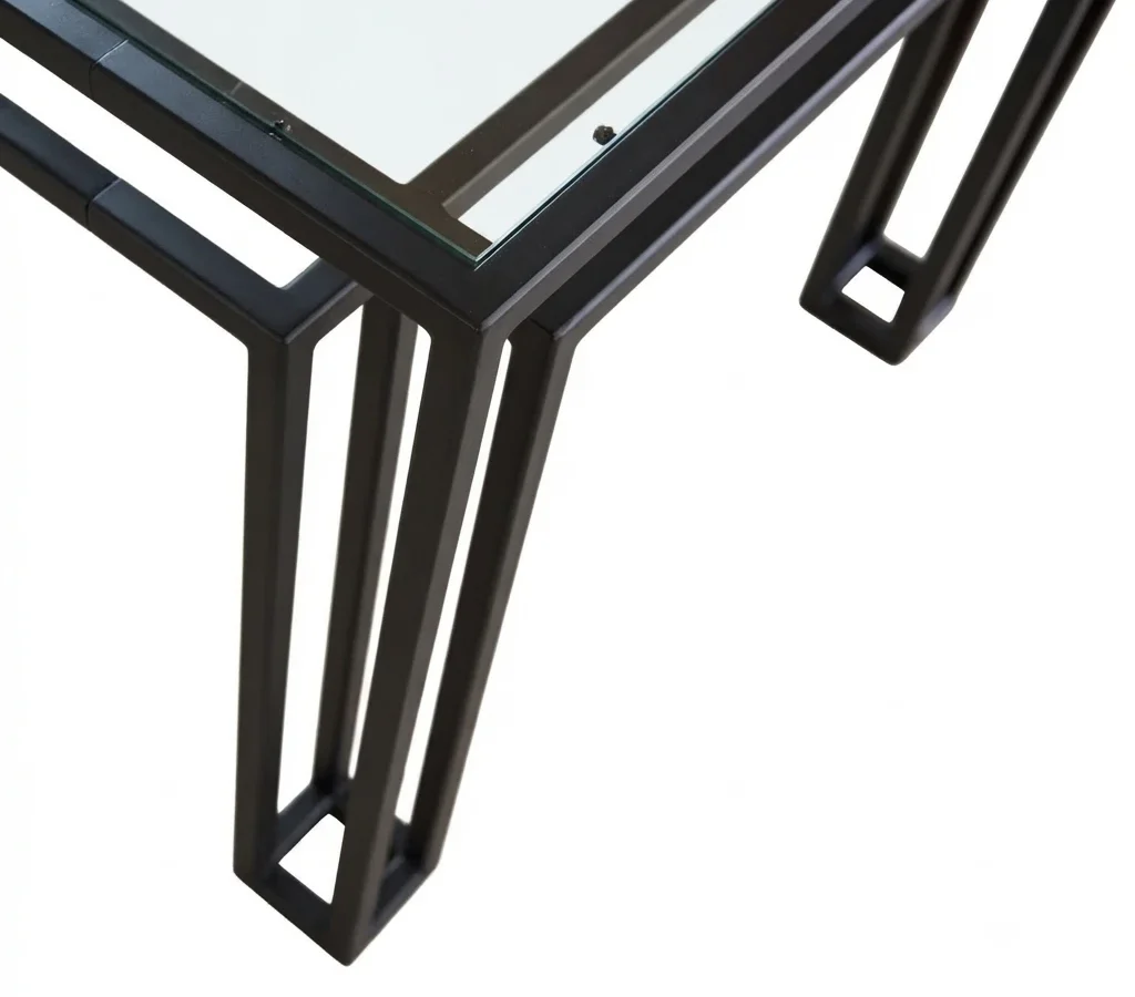 Close-up of a Foundry corner: the inner and outer blackened steel rails crossing beneath the glass top