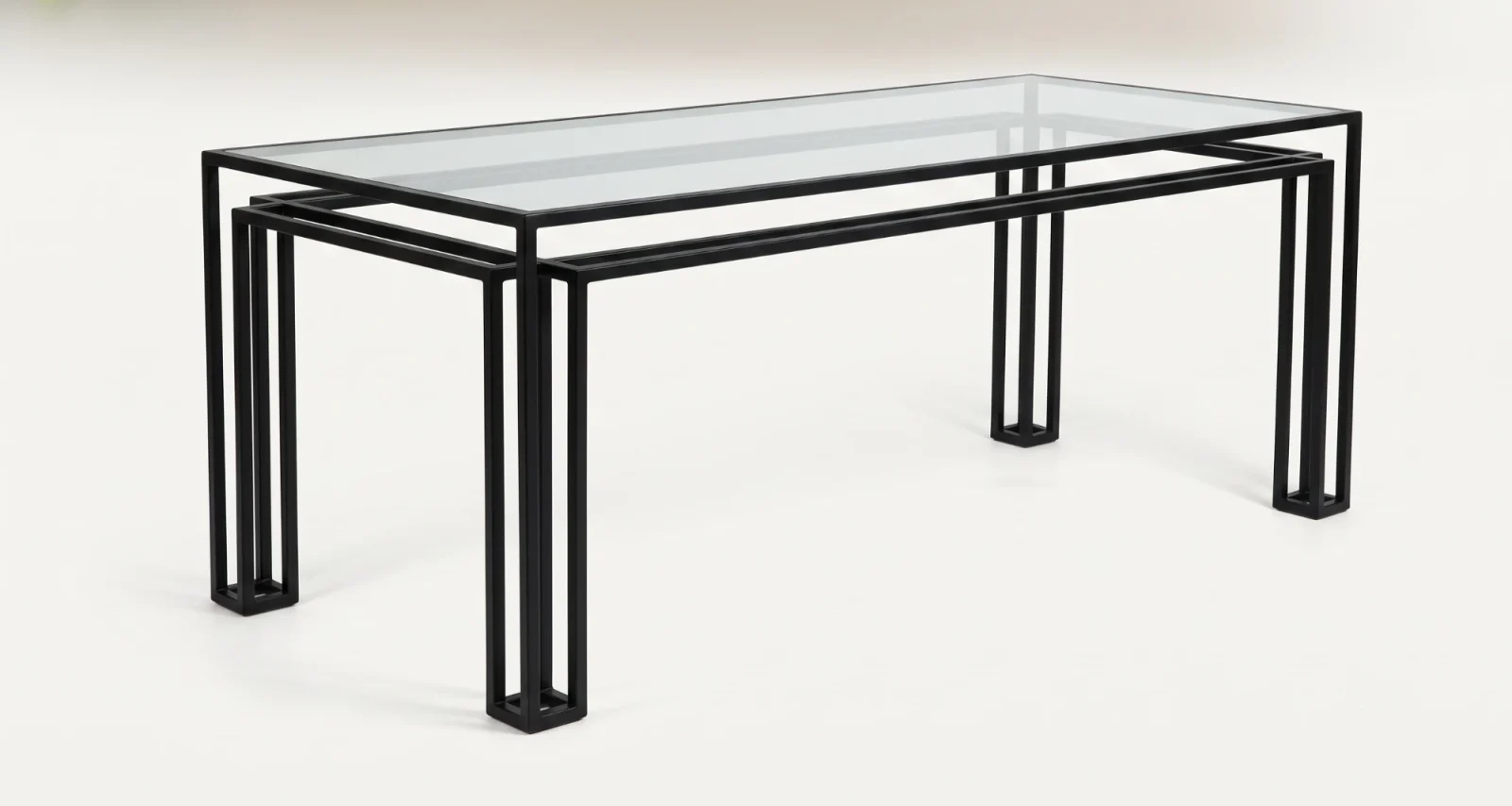 The Foundry Dining Table, three-quarter view, showing the offset double frame and clear glass top