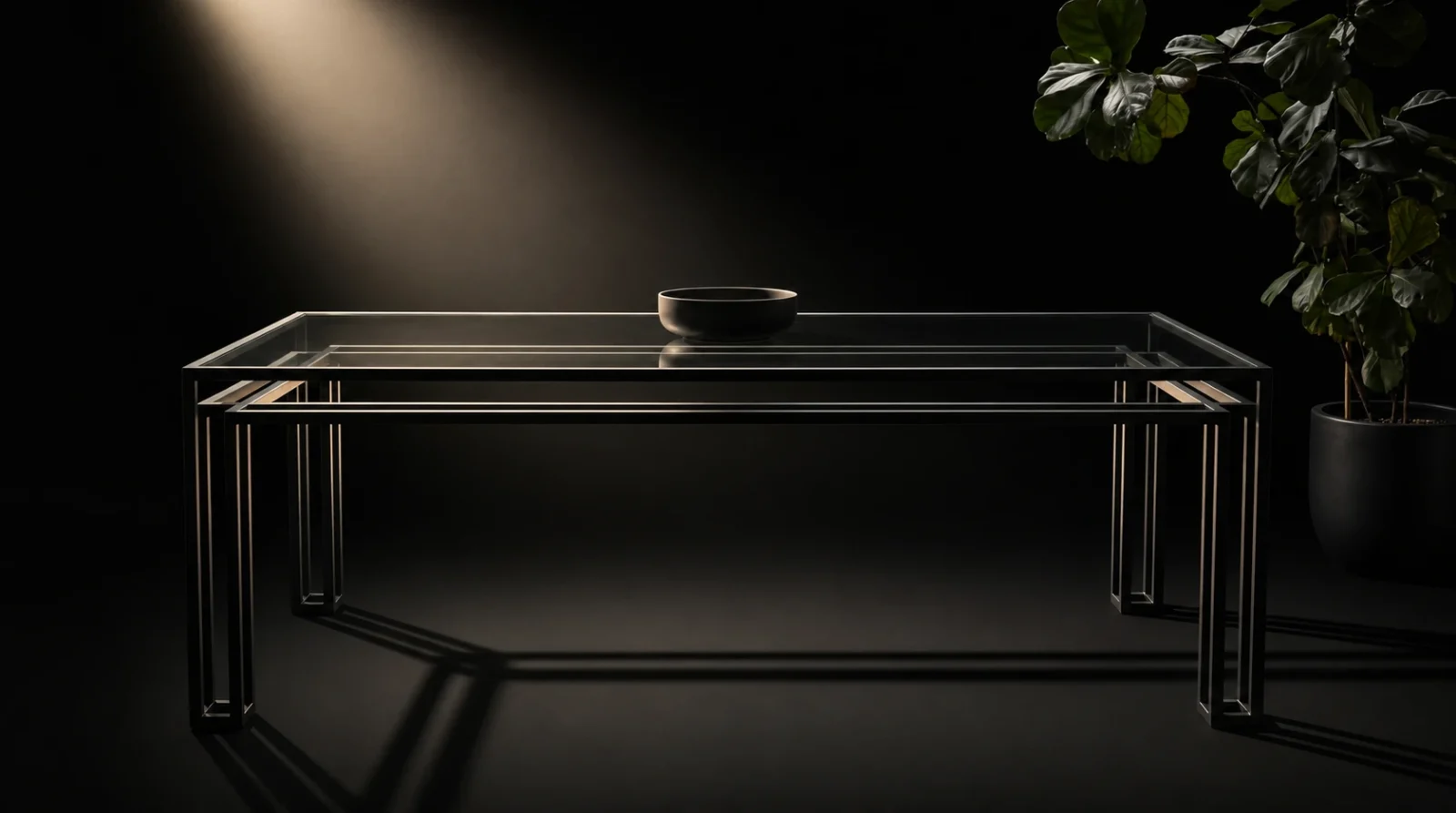 The Foundry Dining Table lit from above against a dark background, the double frame casting a layered shadow