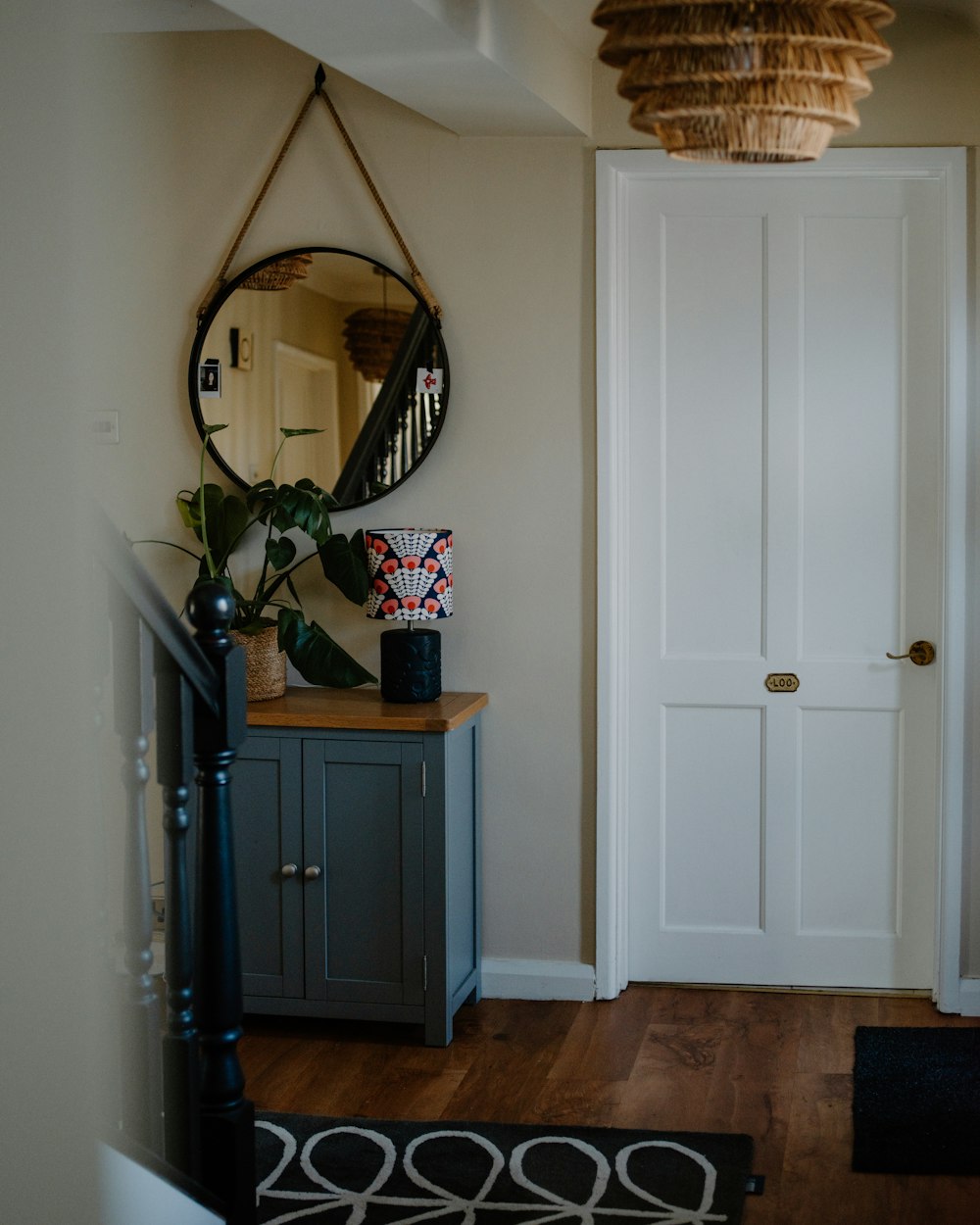 Jamb Console — a hallway with a round mirror and cabinet