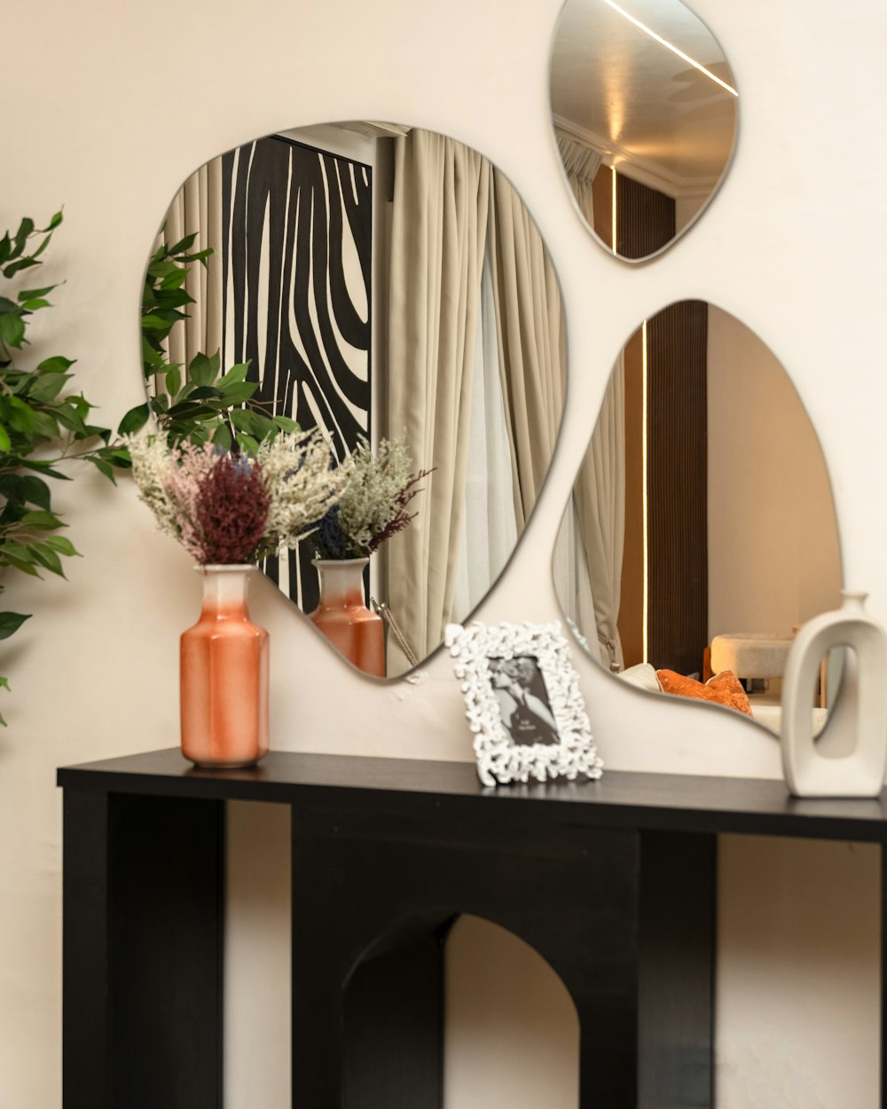 Plinth Console — a console table with mirrors and a plant