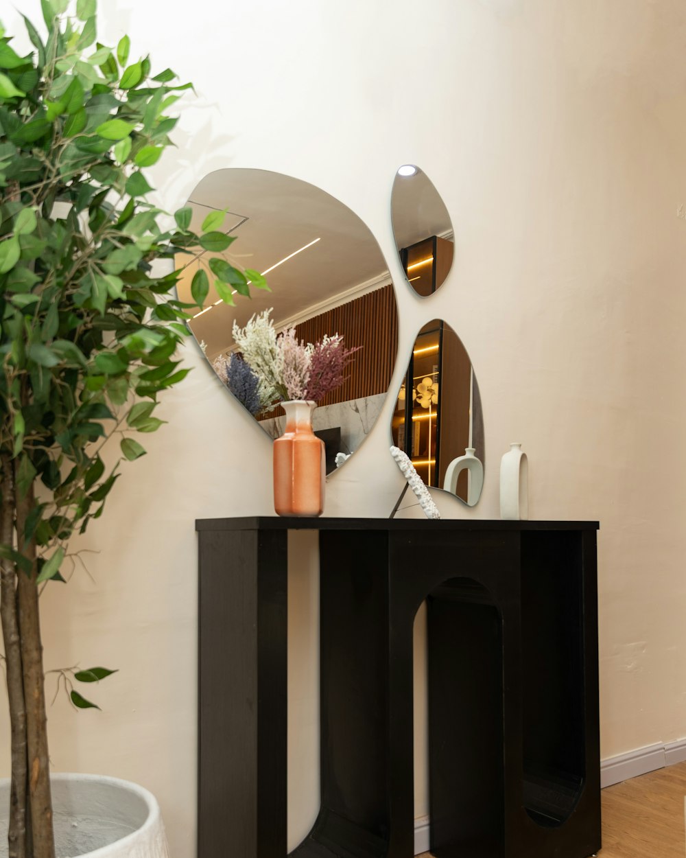 Stile Console — a black console table with a vase