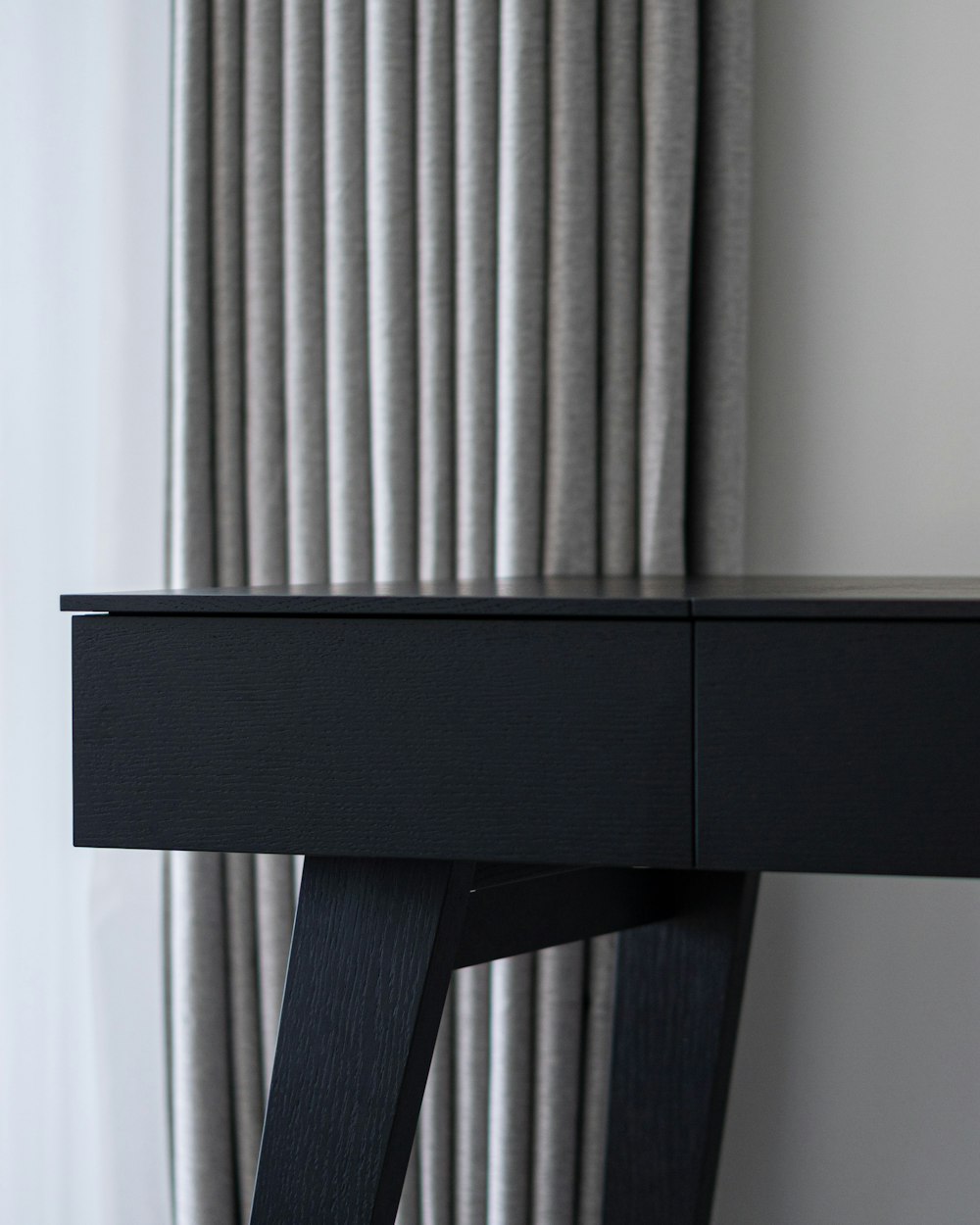 Stile Work Table — a black desk with a clock on it